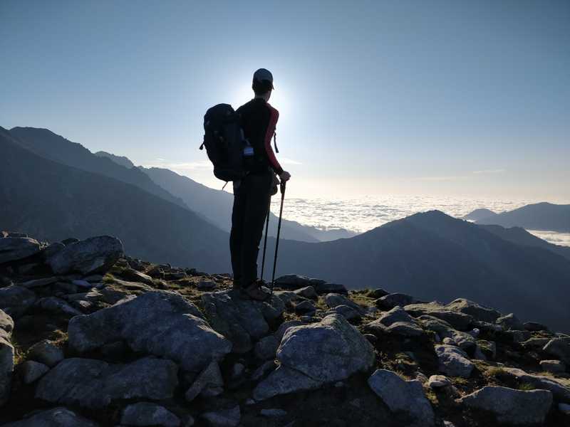Jonas silhouetted against the sunrise, above a sea of clouds filling the valley below