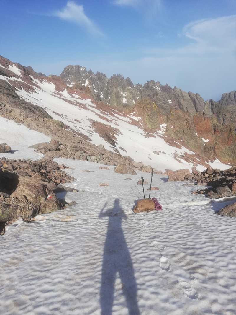 my shadow stretched across untouched snow while hiking alone toward the summit of Monte Cinto