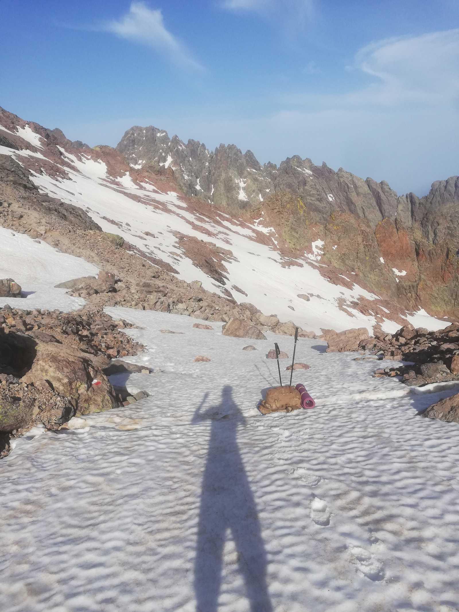 my shadow stretched across untouched snow while hiking alone toward the summit of Monte Cinto