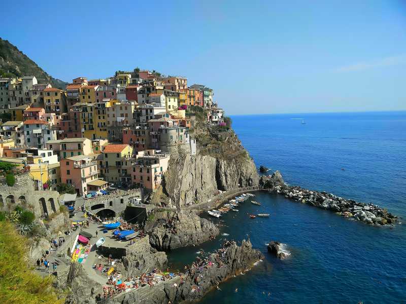the pastel houses of Cinque Terre stacked into the cliffs above the sea