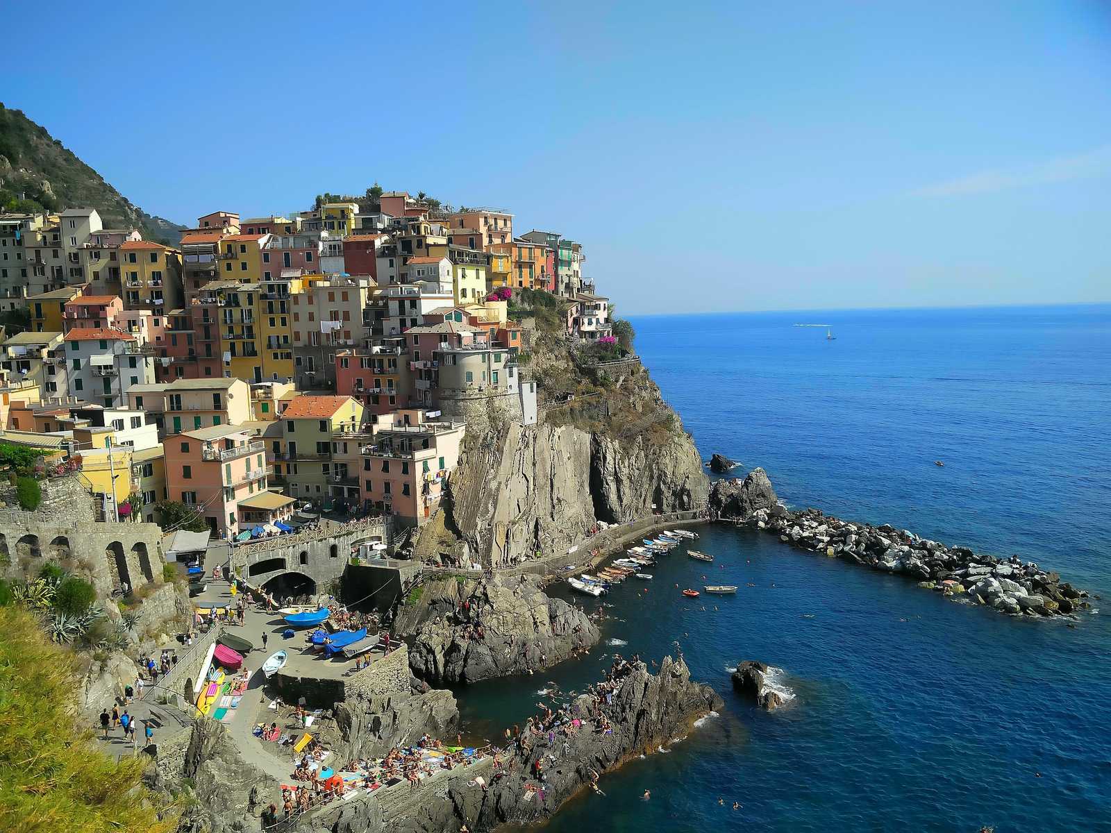 the pastel houses of Cinque Terre stacked into the cliffs above the sea